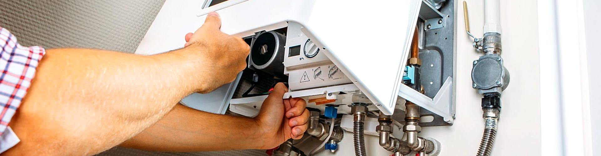 Plumber attaches Trying To Fix the Problem with the Residential Heating Equipment. Repair of a gas boiler